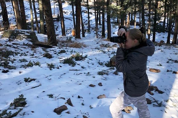 Person photographing out in the snowy woods