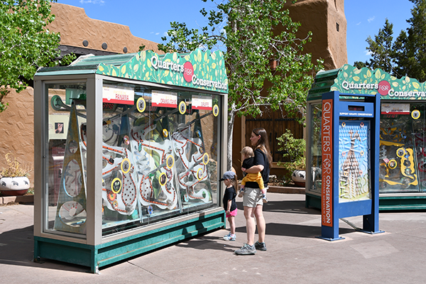 Quarters for Conservation kiosk with mother and child voting using tokens