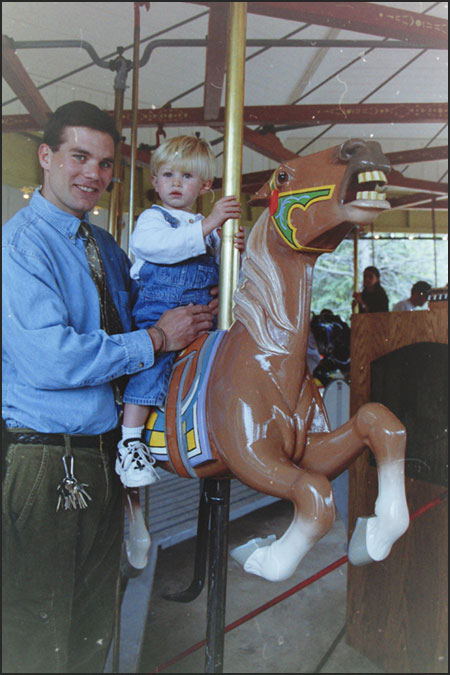 Bob Chastain on carousel with his son at Cheyenne Mountain Zoo
